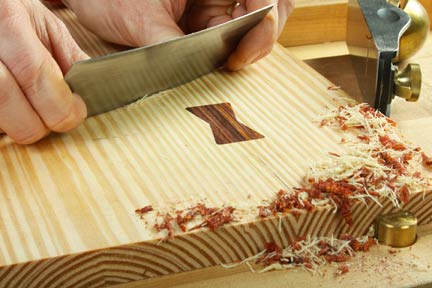 Smoothing down inlay insert to rest of project with scraper