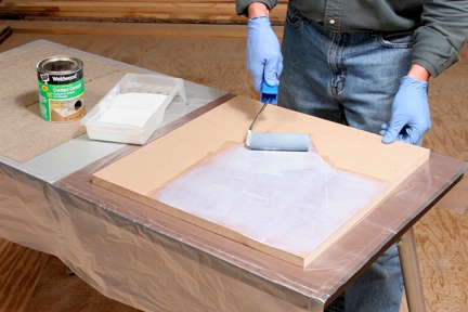 Rolling contact cement on back of laminate sheet
