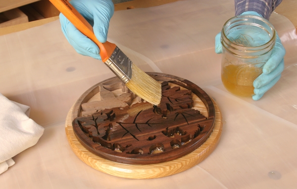 Brushing a polyurethane and mineral oil finish on a round trivet