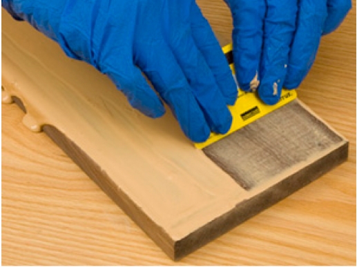 Spreading grain filler on board