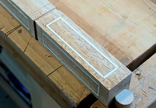 Decorative veneer stringing in a table leg