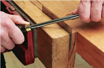 Sharpening scraper in vise with burnisher