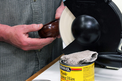 Buffing a wax finish with a cloth buffing wheel in grinder