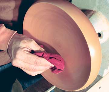 Applying friction polish to a turned maple bowl