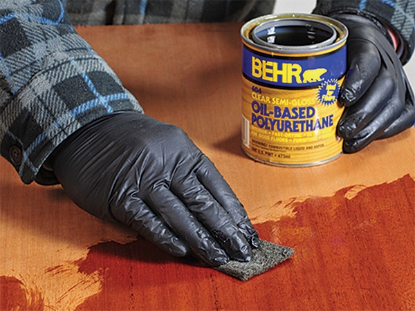 Wiping oil based polyurethane finish on a piece of maple plywood
