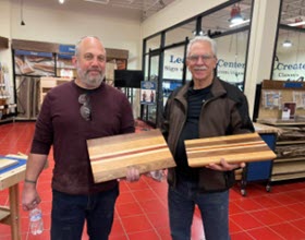 two men showing off their completed cutting boards from a Rockler class