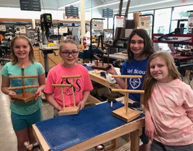 girl scout troop showing off their jewelry stands made during a Rockler class