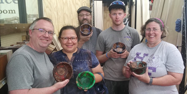 Group of students holding completed turned bowls woodworking project